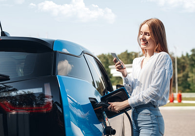 Lady checking her EV service and maintenance needs on a smartphone