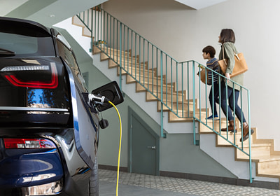 home charging cars while woman walks up stairs with boy
